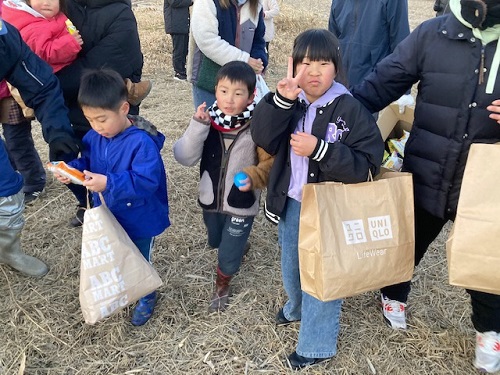 袋いっぱいのまき物を拾ってご機嫌な子どもたち