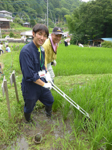 地元の方の指導を受けて田の草取り