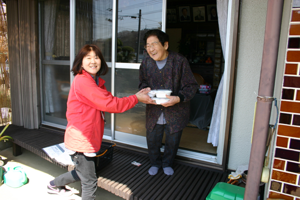 宅配給食を手に　にっこり